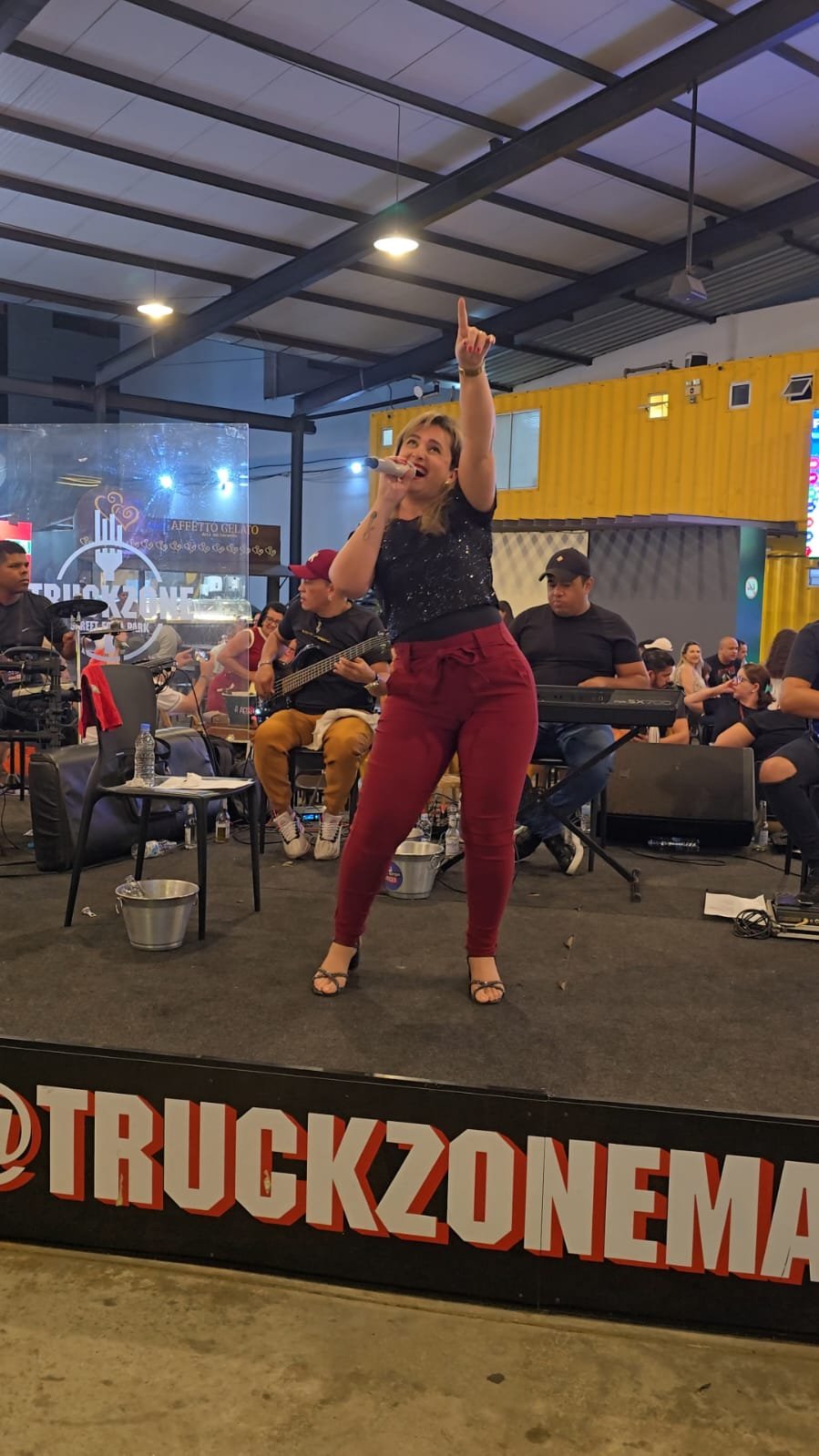 Angelina cantando com a banda diante do público