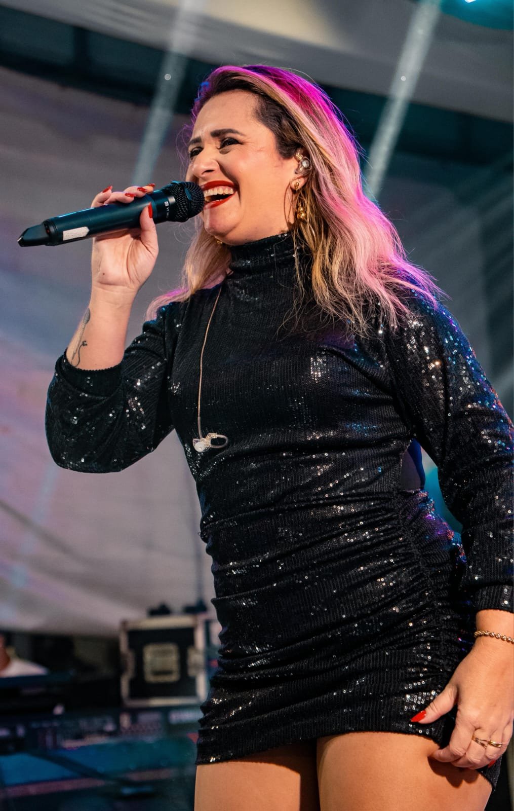 Angelina sorrindo e cantando ao microfone